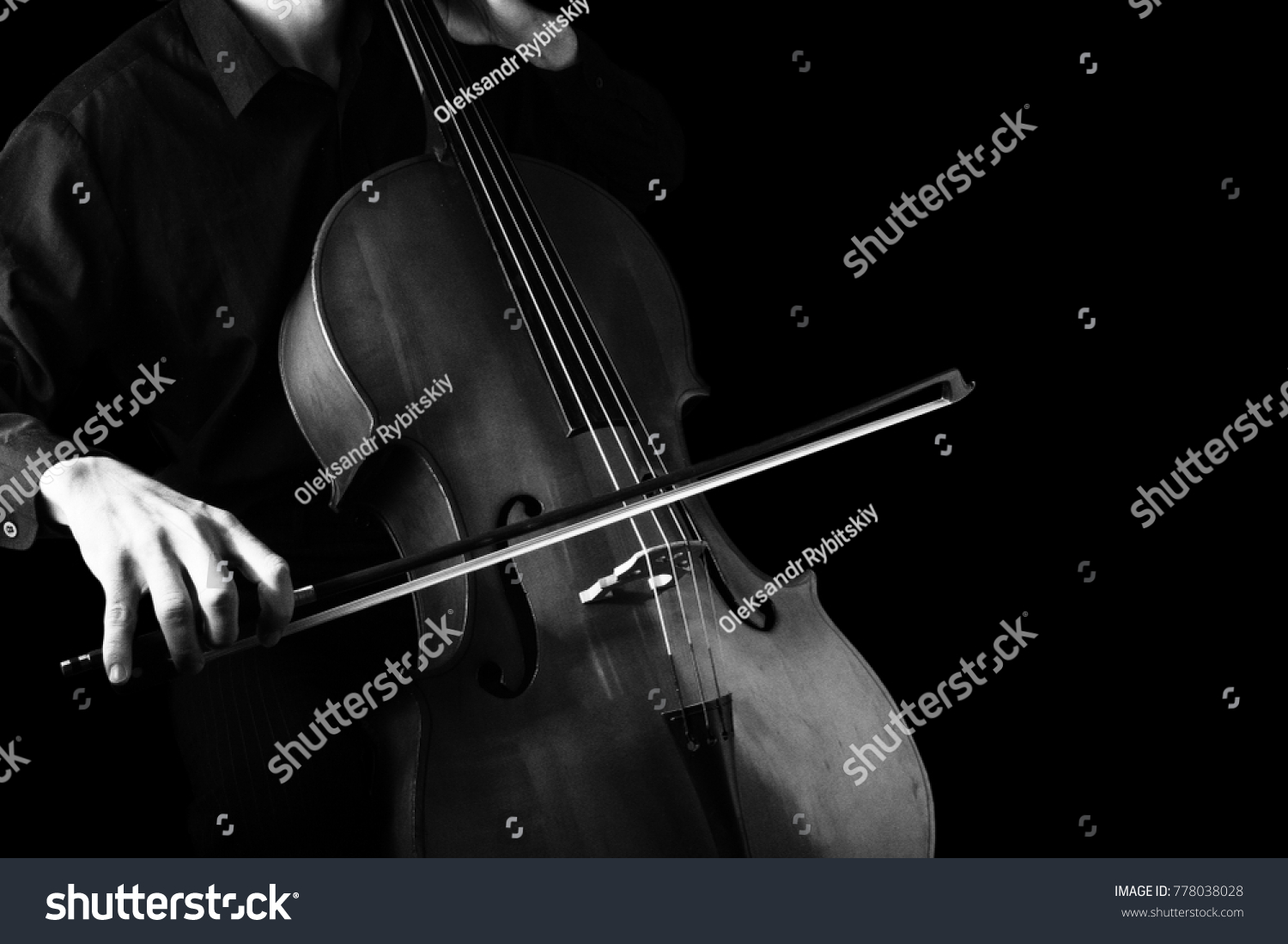Man playing on cello on black background. String instruments #778038028