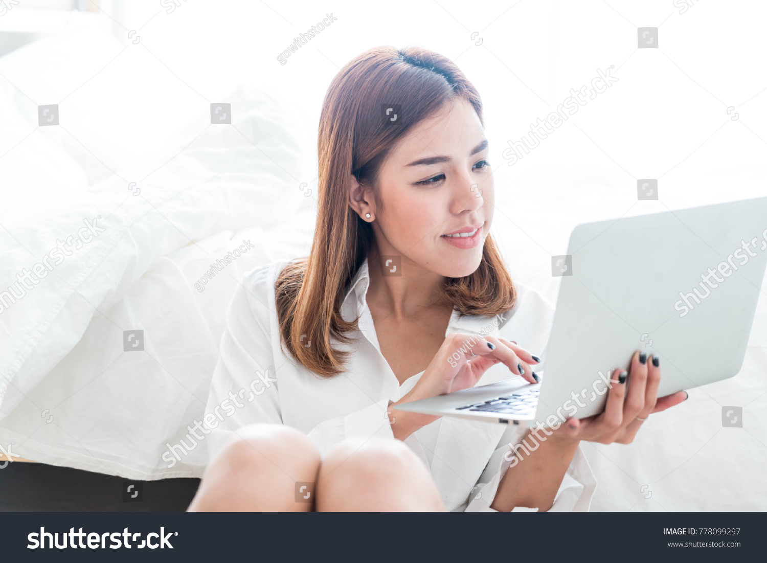 Beautiful asian woman working at home with laptop and telephone #778099297