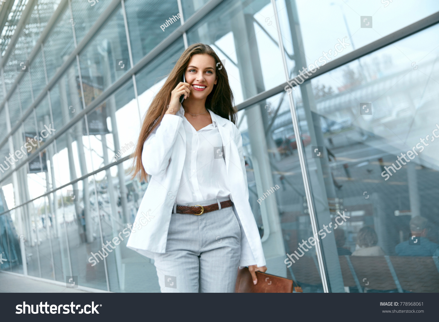 Business Woman With Phone Near Office. Portrait Of Beautiful Smiling Female In Fashion Office Clothes Talking On Phone While Standing Outdoors. Phone Communication. High Quality Image. #778968061