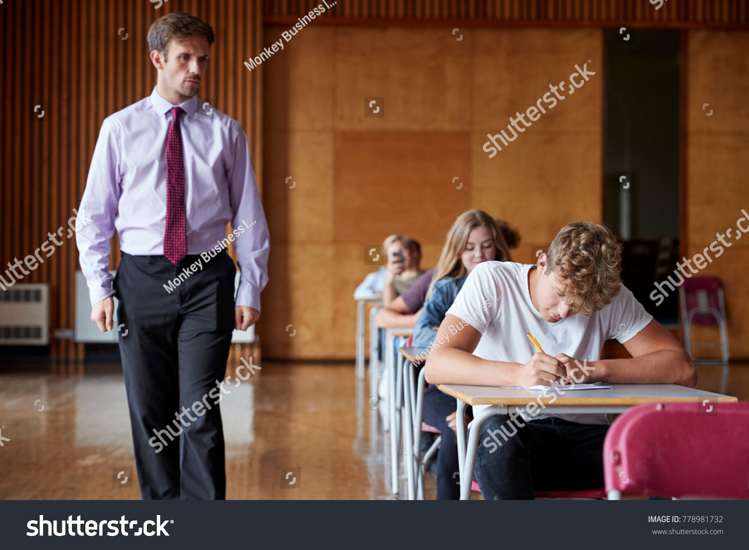 Teenage Students Sitting Examination With Teacher Invigilating #778981732
