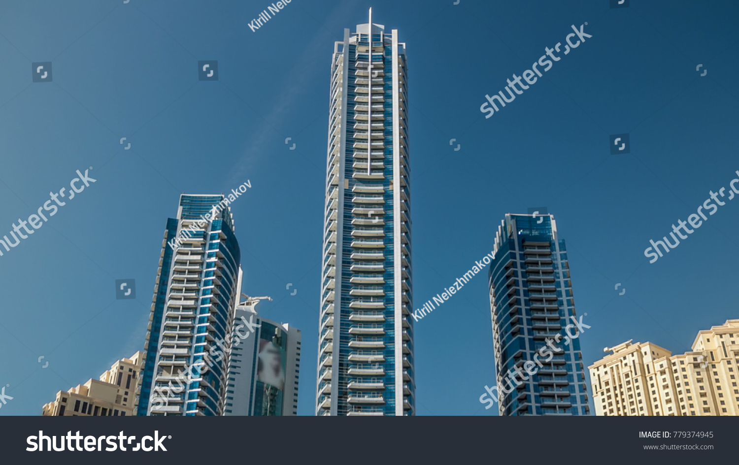 Close up View on Dubai Marina blue towers from pier with blue sky. Timelapse hyperlapse of business city in Dubai at waterfront, UAE #779374945