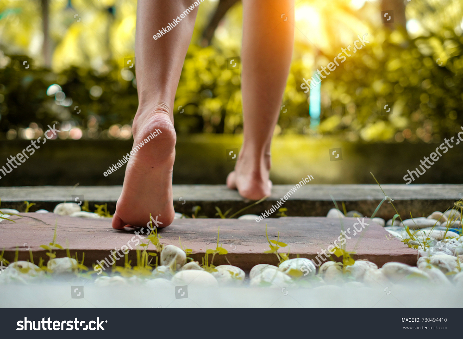 barefoot girl walking on the stone floor in outdoor with sunlight #780494410