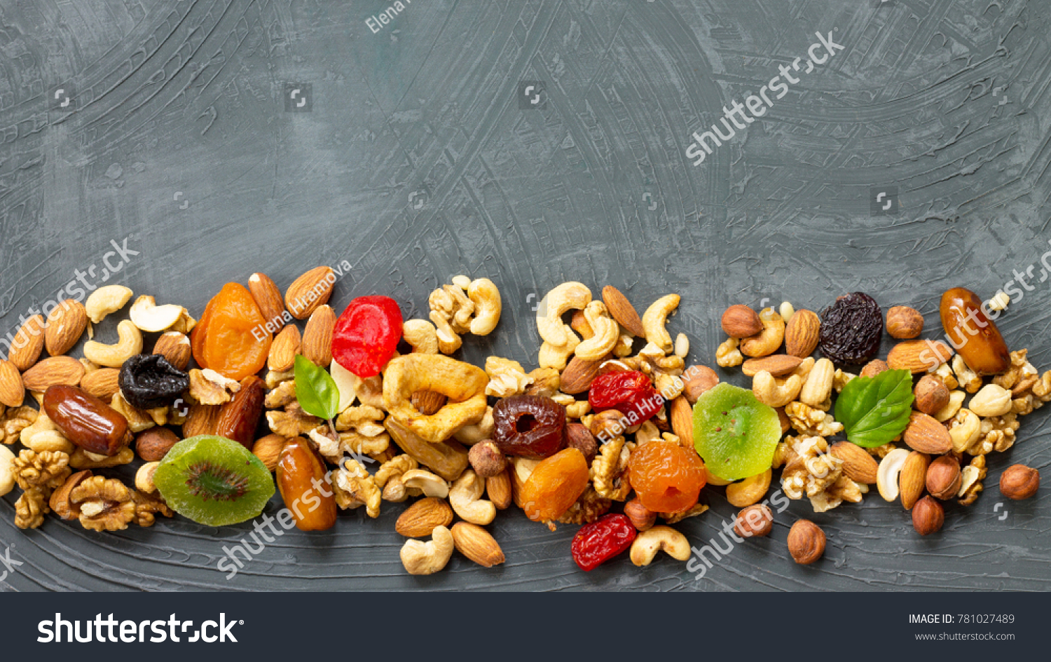 Various dried fruits and mix nuts on a gray stone or slate background.  The concept of the Jewish holiday Tu Bishvat. Flat lay, top view with copy space. #781027489