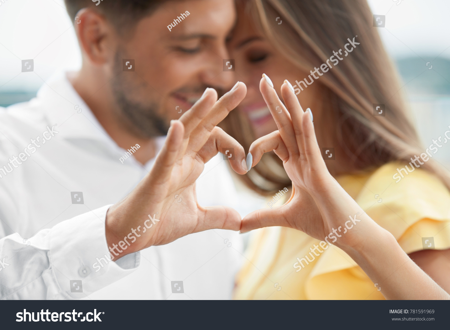 Beautiful Couple In Love Making Heart With Hands. Happy Smiling Young People Hugging, Showing Heart Shape With Hands And Enjoying Each Other Outdoors. Romantic Relationships. High Quality Image. #781591969