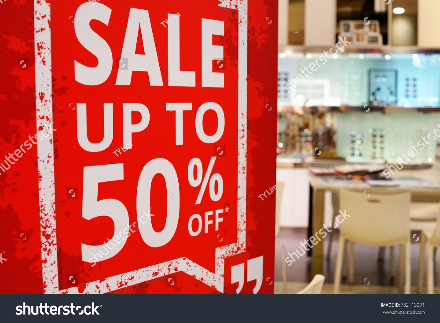 Sale up to 50% off text on a sign board inside a popular optic store  #782113291