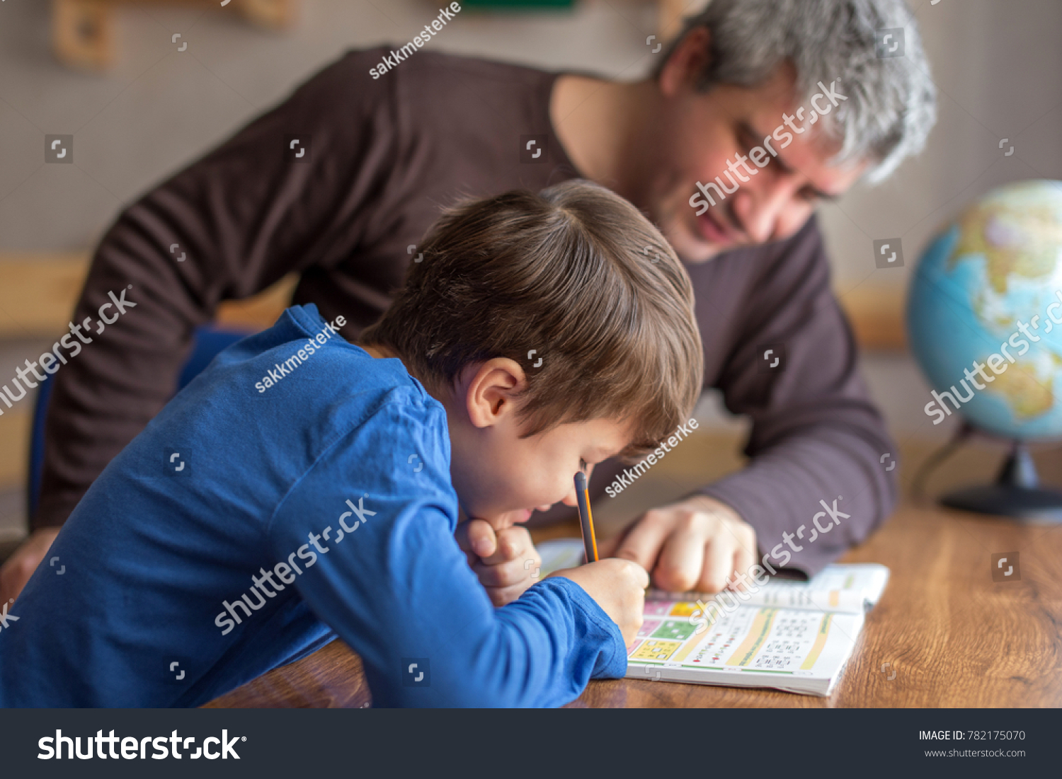 Young little shoolboy solving mathematics homework with father, cooperation in family, parenthood #782175070