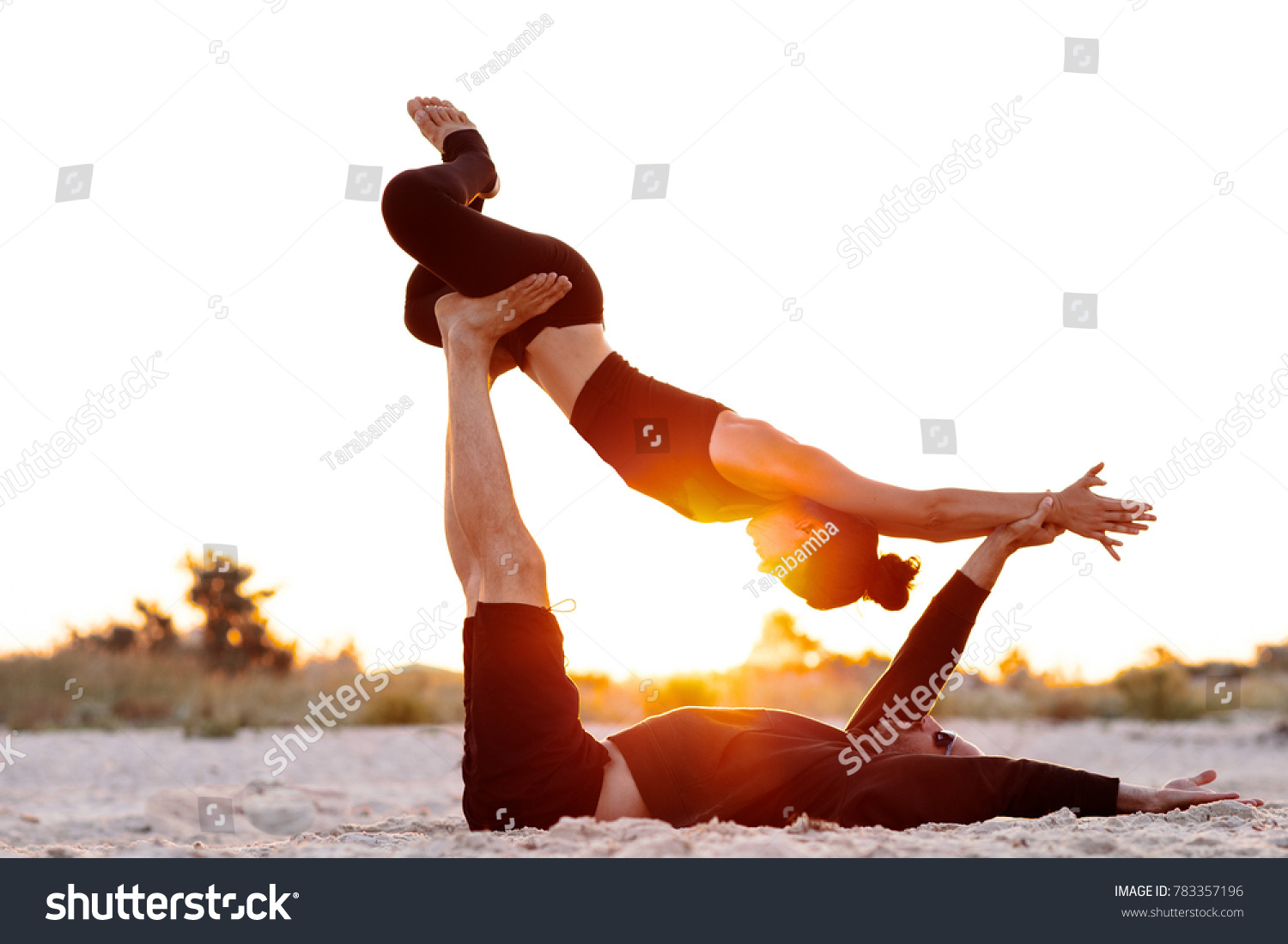 man and woman doing acrobatic yoga early in the morning #783357196