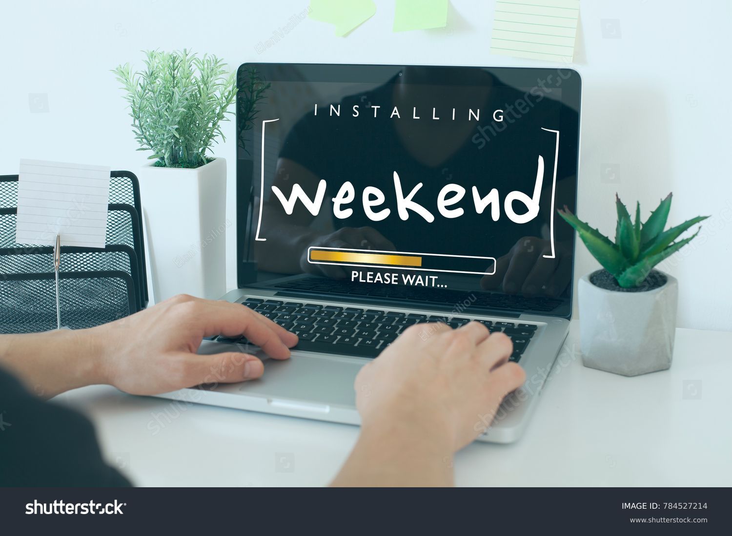 Installing weekend please wait note concept / Hands on laptop in office #784527214