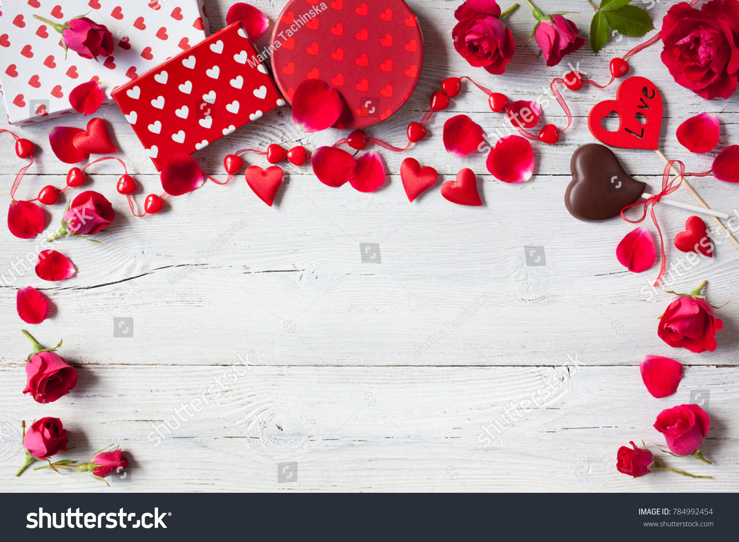 Roses and red hearts on a wooden background and gifts in boxes #784992454