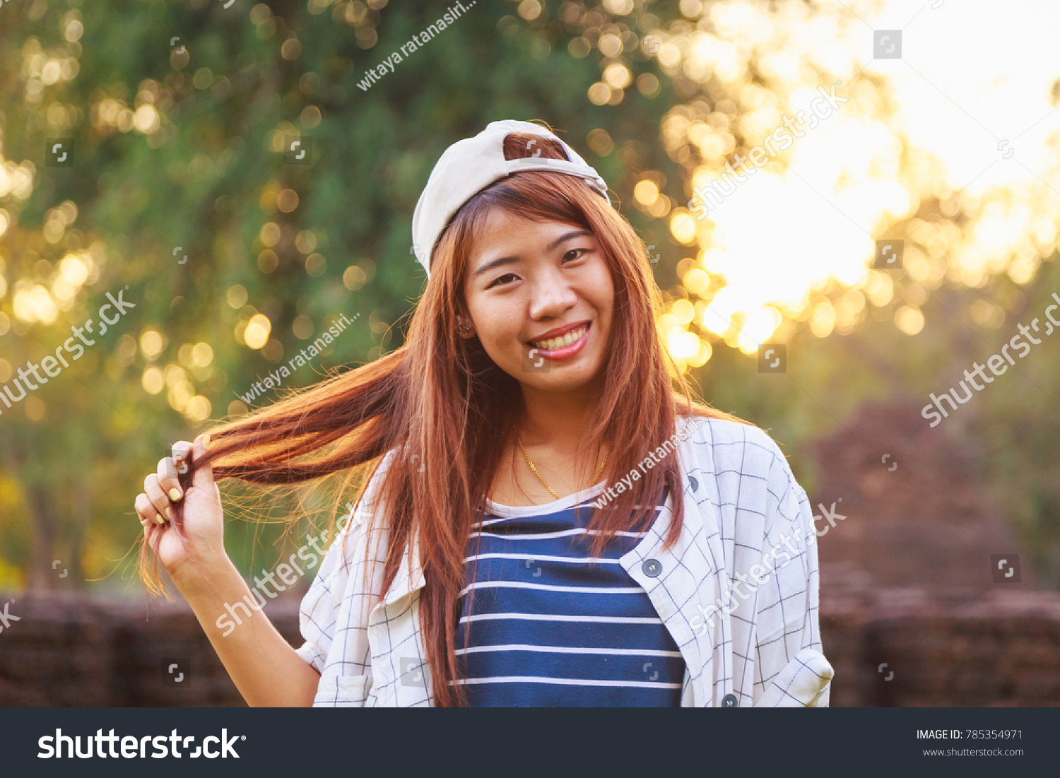 pretty Asian tourist woman outdoor portrait with sunset sky background #785354971