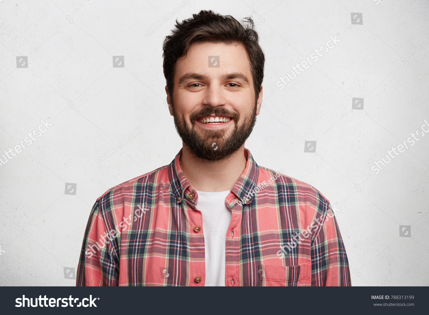 Smiling bearded young male model rejoices coming weekends, dressed casually, isolated over white background. Positive pleased student being in good mood after successfully passed exams at college #788313199