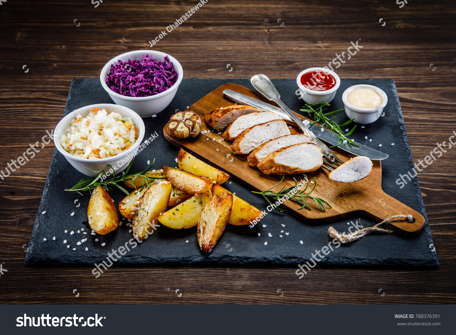 Roast chicken breast and baked potatoes on cutting board #788376391