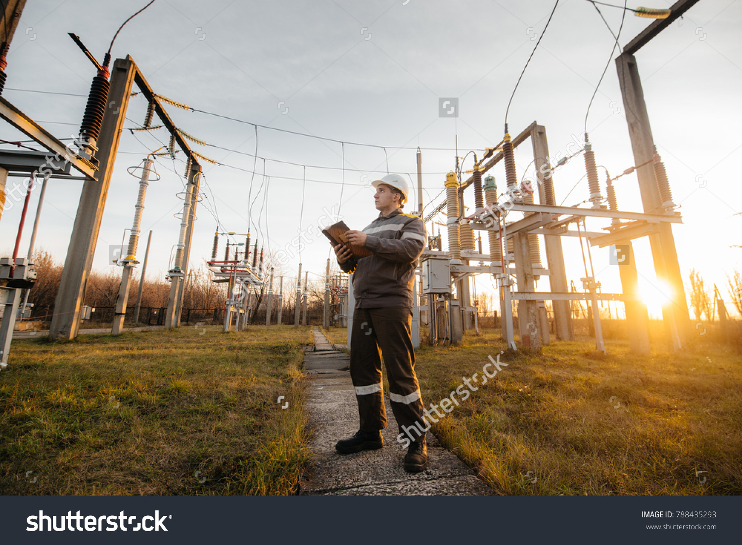 The energy engineer inspects the equipment of the substation. Power engineering. Industry. #788435293