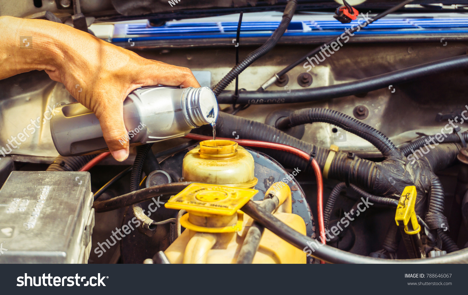 Mechanic  pouring Brake fluid to brake oil tank in service shop #788646067