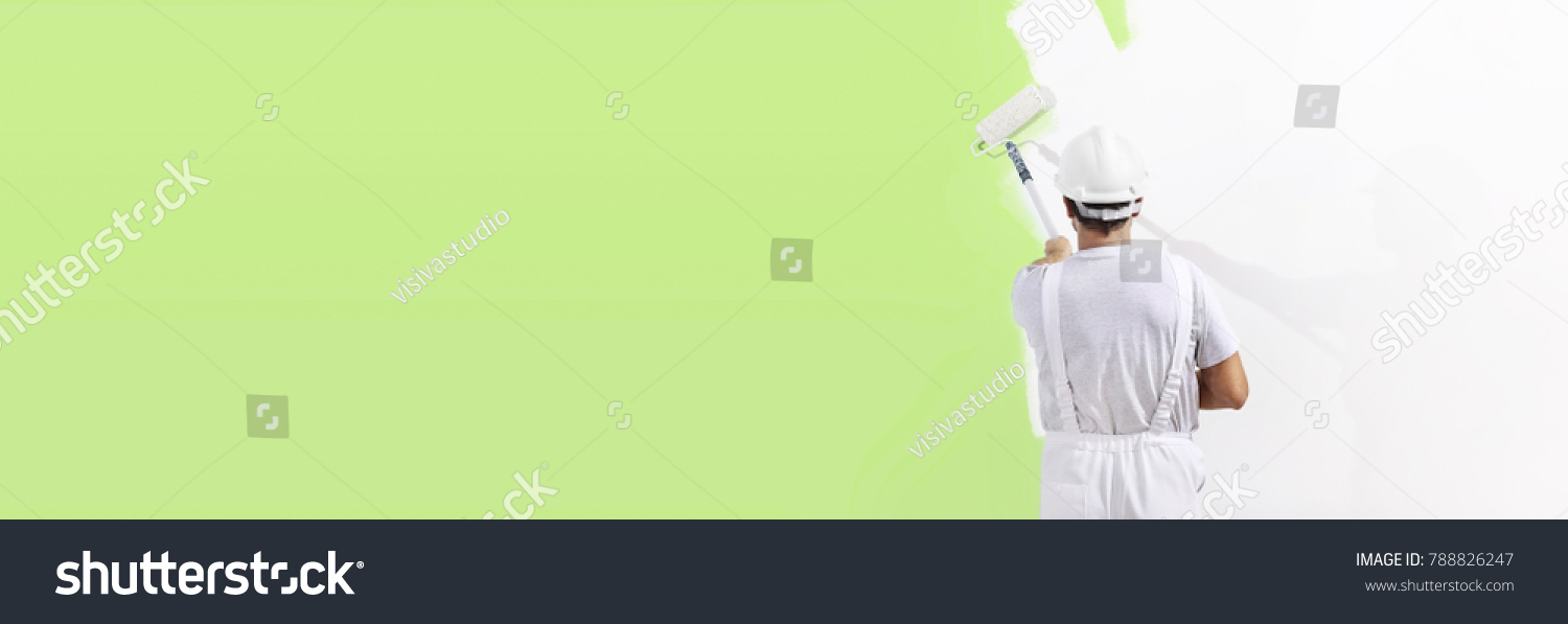 painter man at work with a paint roller, wall painting green color ecological concept, web banner template #788826247