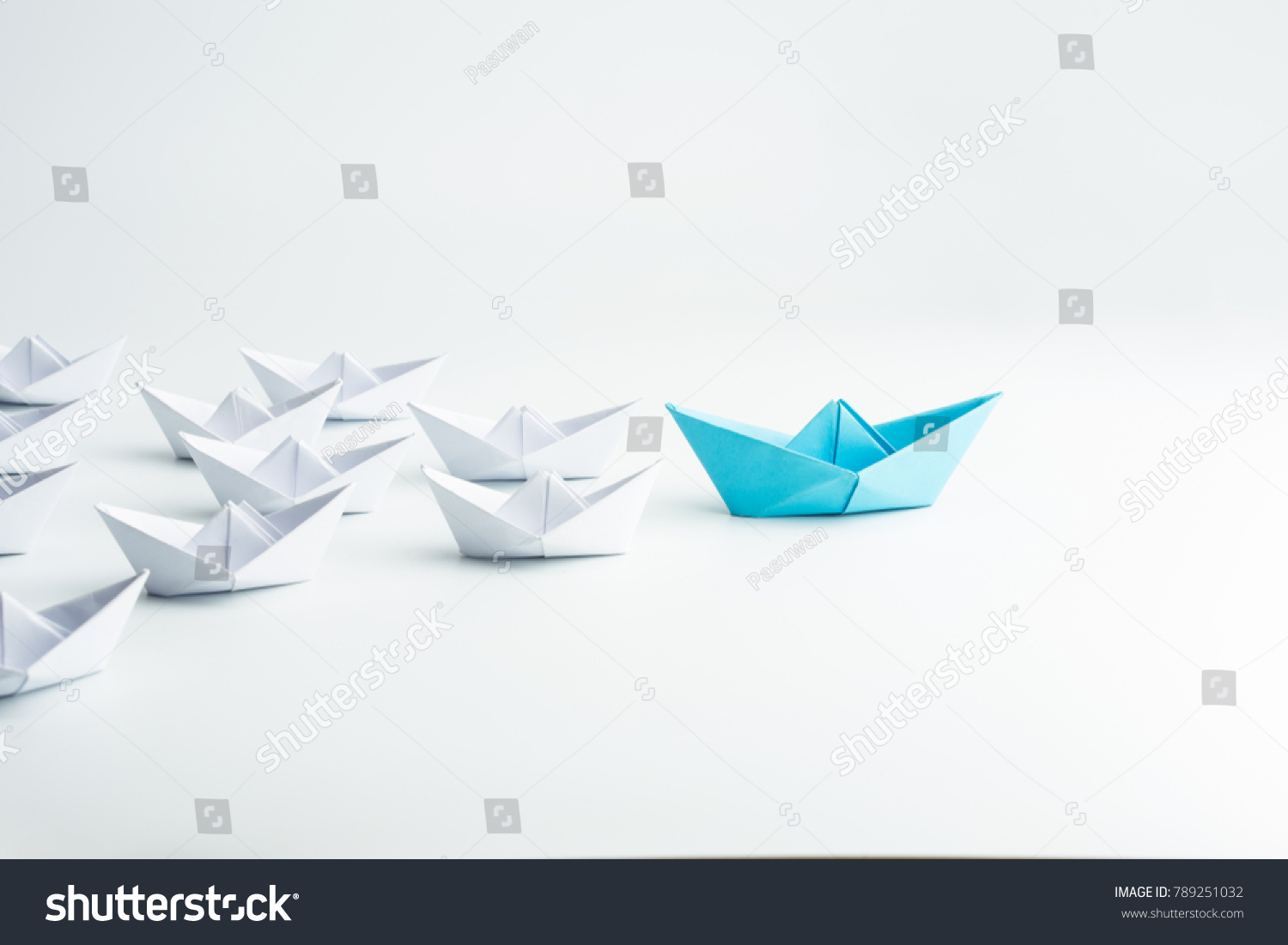 Leadership concept with blue paper ship leading among white #789251032