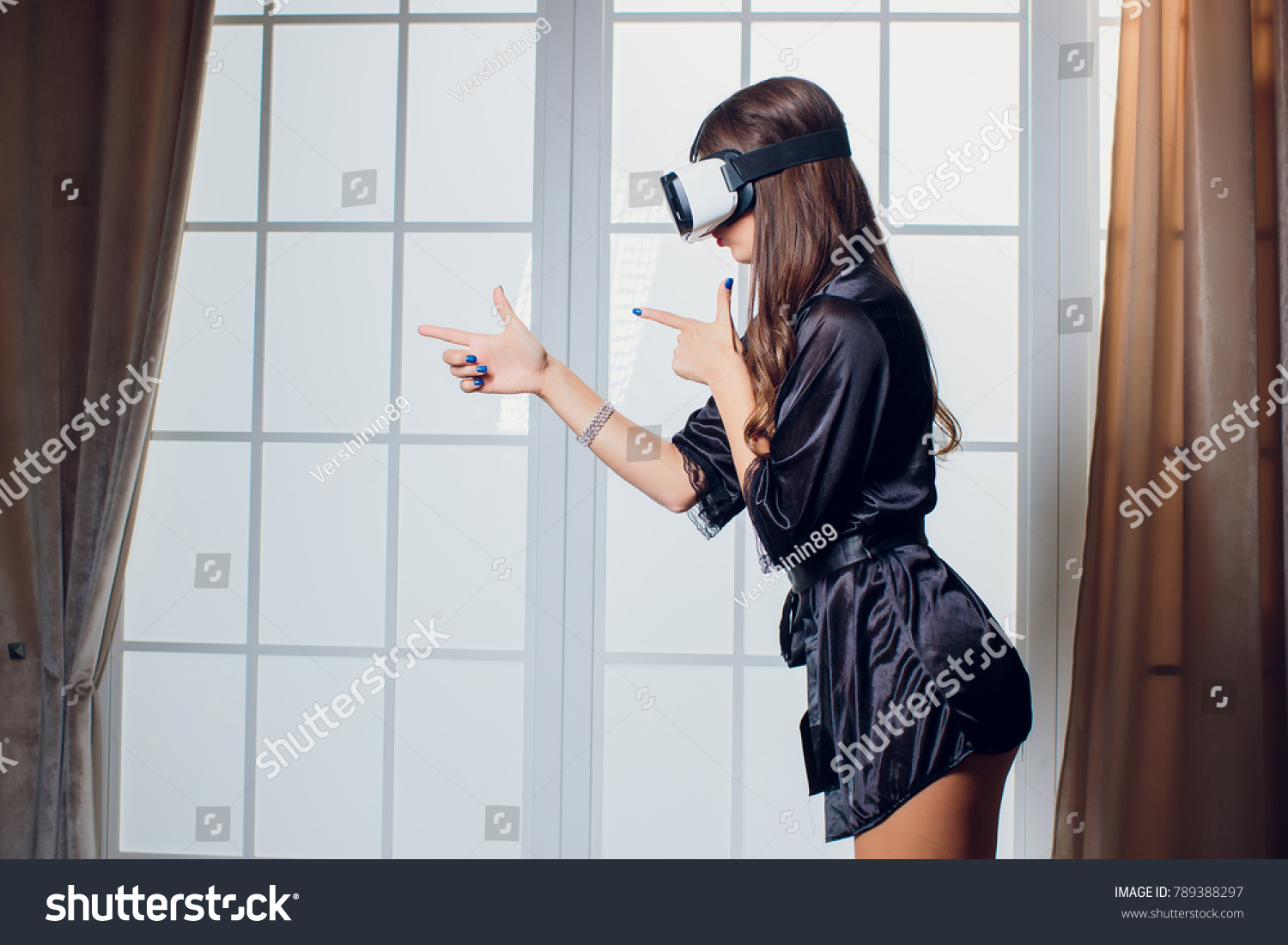 Beautiful woman wearing Lingerie using vr-goggles in bed. #789388297