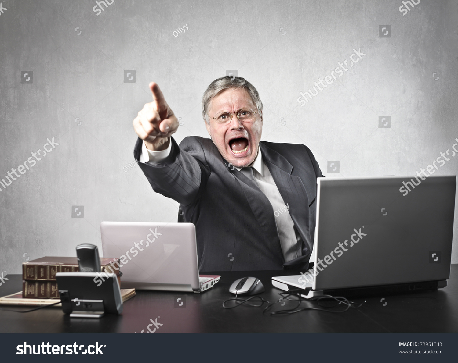Angry senior businessman sitting at his desk and screaming #78951343