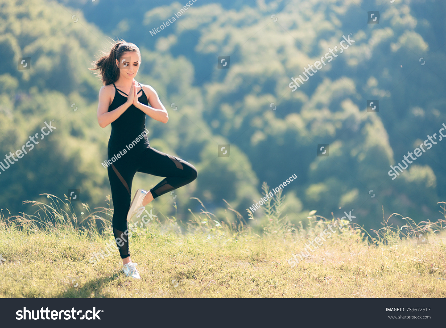 Woman in Tree Yoga Pose Wearing  Overall Jumpsuit Exercising Outside. Fit girl in sporty outfit active wear outdoors in nature ready to exercise
 #789672517
