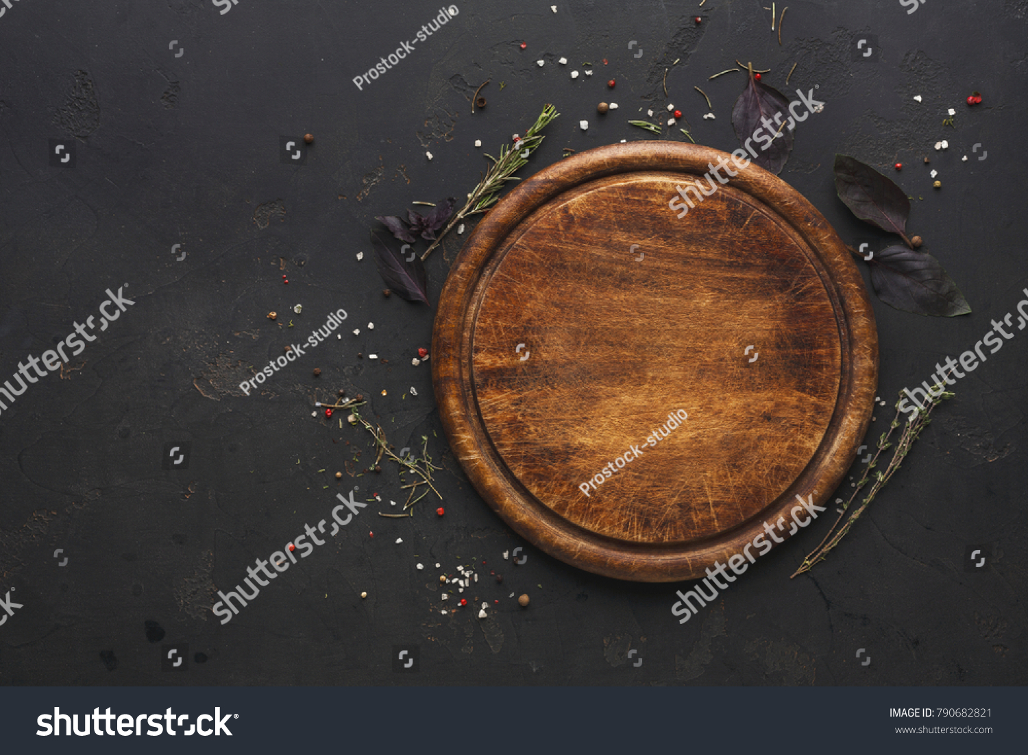 Round wooden plate with herbs and salt on dark wooden background top view #790682821