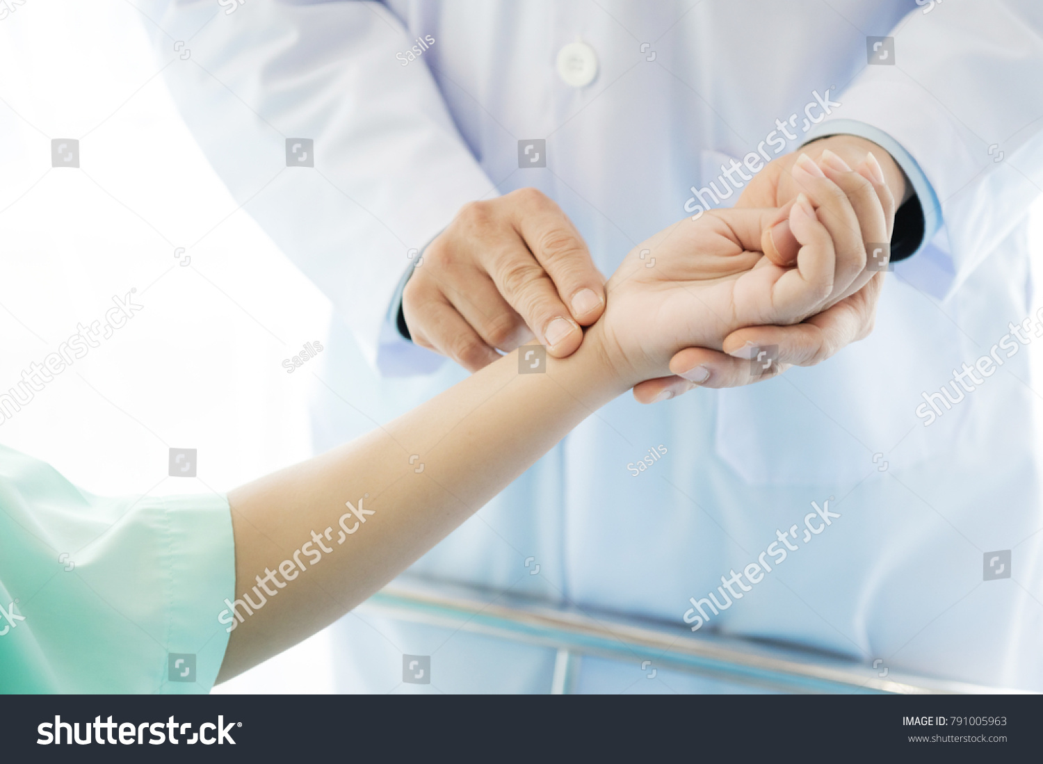 Doctor with patient. Routine health check and holding hands. Male medical doctor with young chinese woman. #791005963