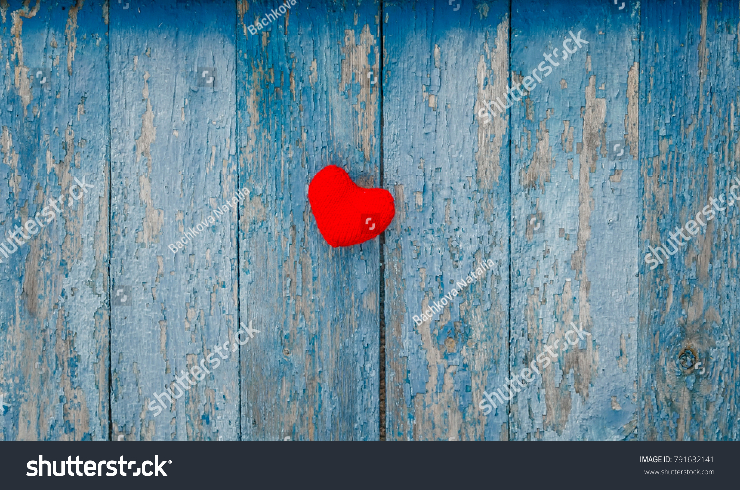 cute red heart knitted of yarn on the wall with old peeling blue paint #791632141