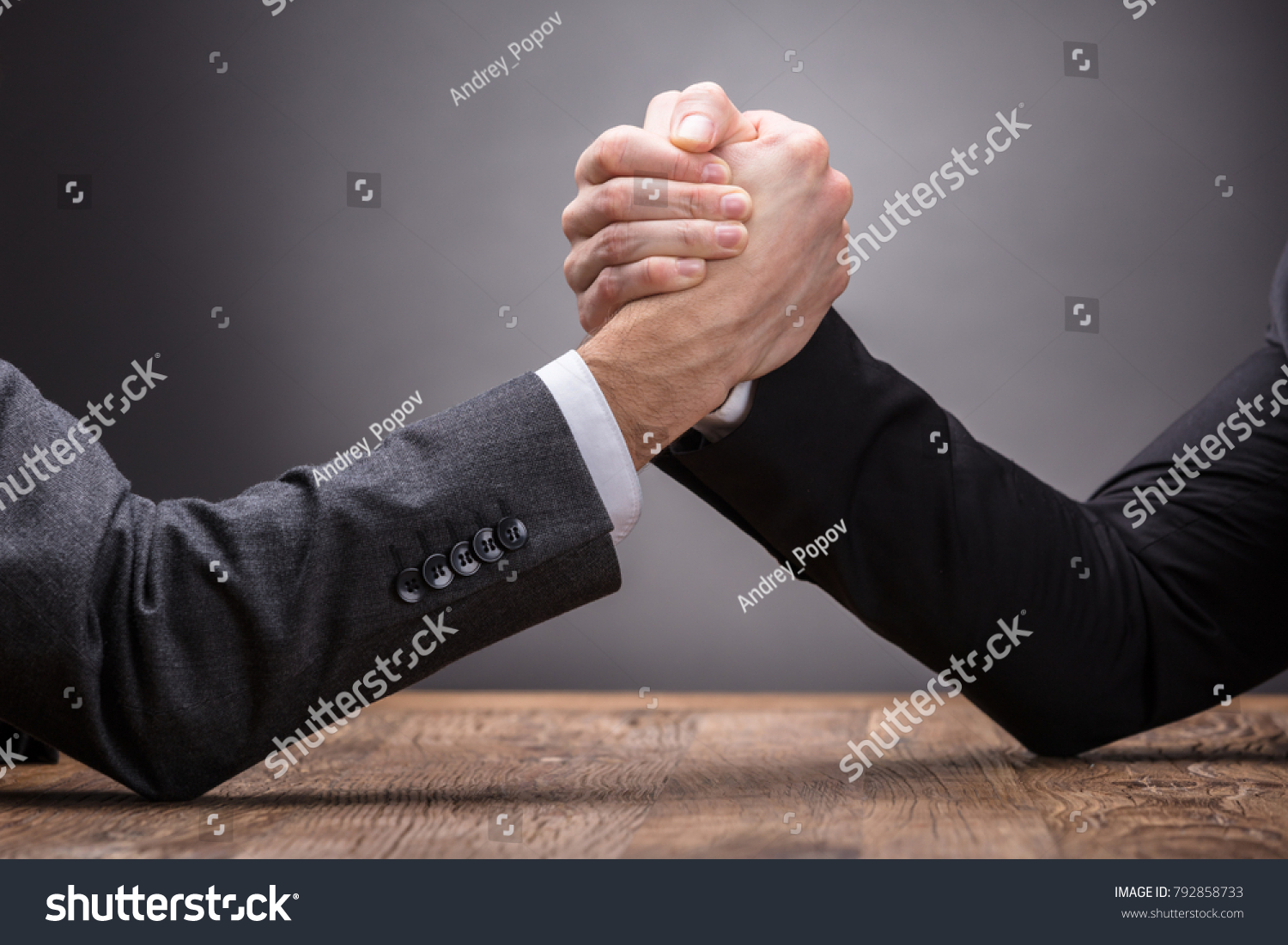 Close-up Of Two Businesspeople Competing In Arm Wrestling On Grey Background #792858733