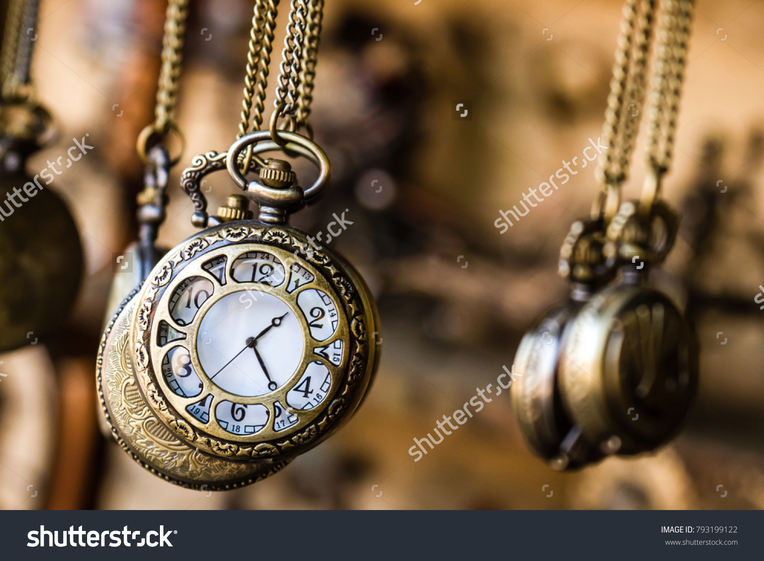 Vintage pocket watchs hanged with chains in an antique shop #793199122
