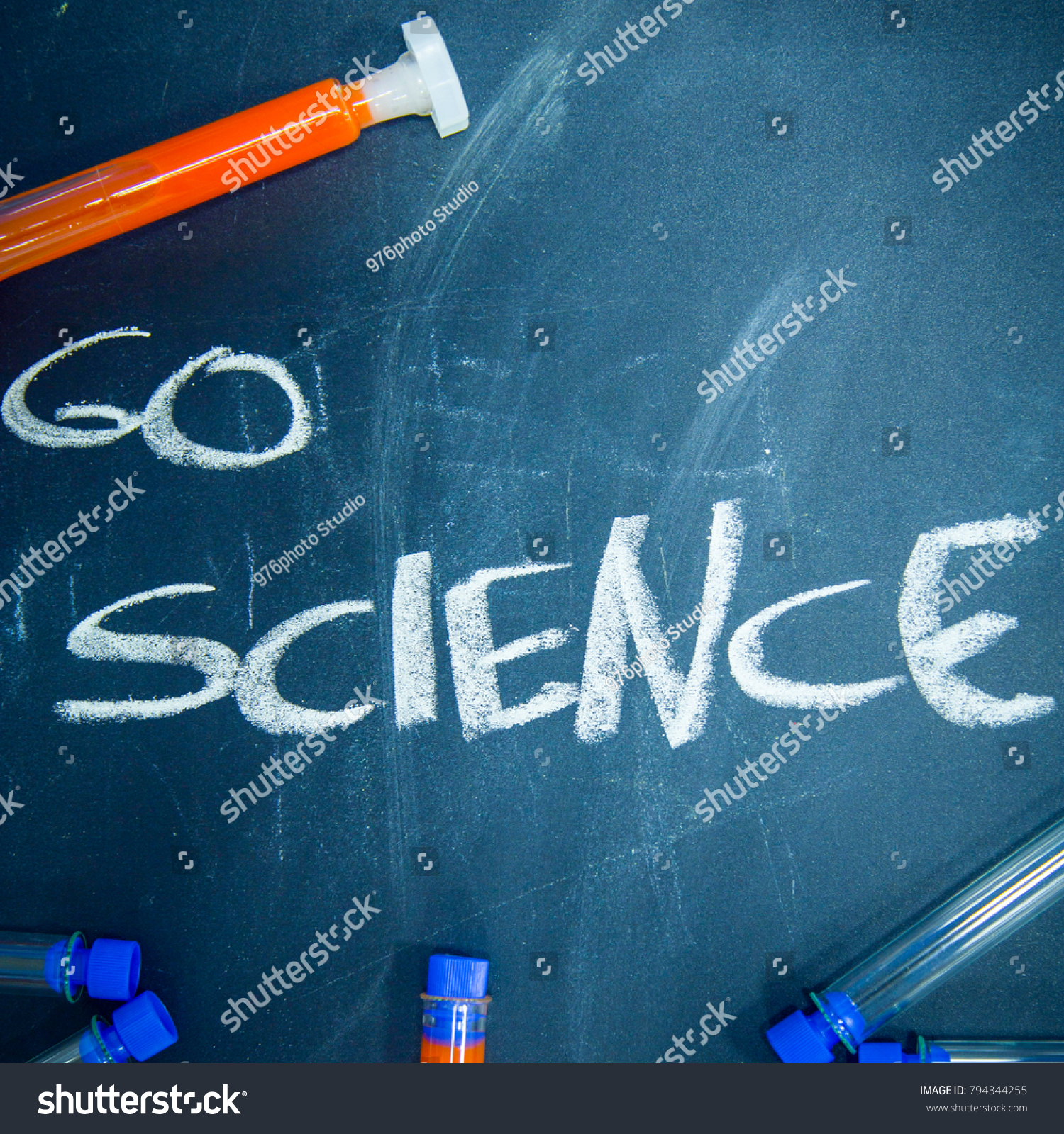 Education concept: Go Science inscribed with colored chalks on a black chalkboard and chemistry flasks, top view, close up, square crop #794344255