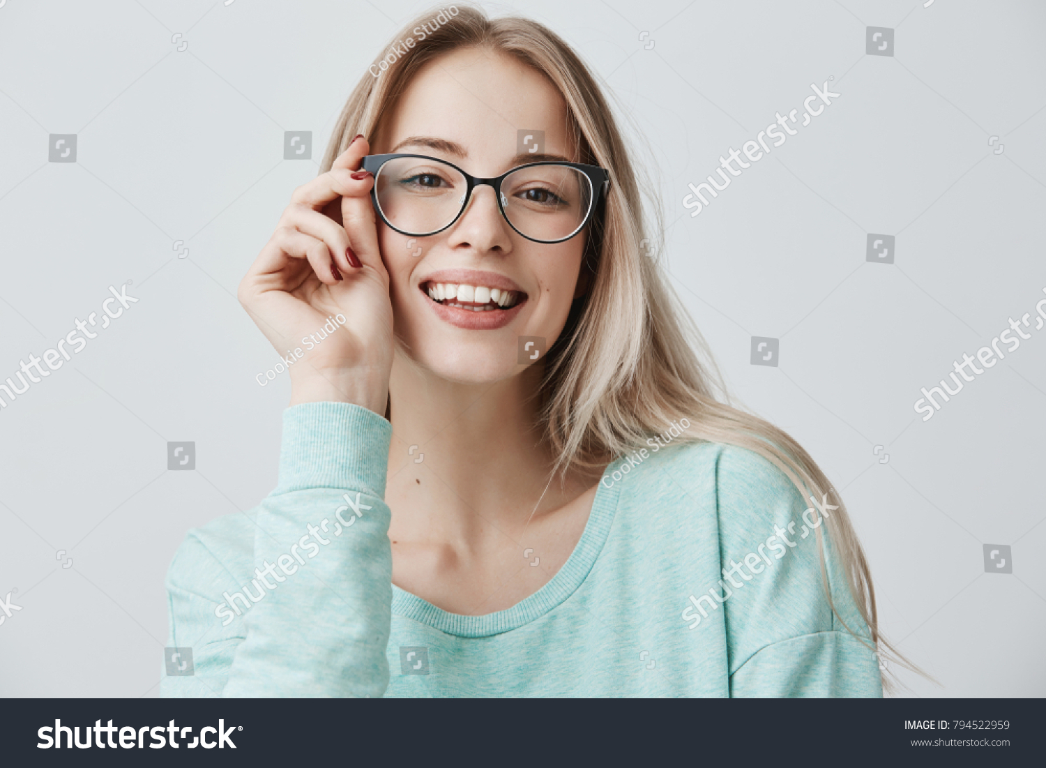 Cheerful female student in stylish eyewear rejoices successfully passed exams, glad to have meeting with groupmates. Delighted beautiful pleased woman has attractive look, poses indoors. #794522959