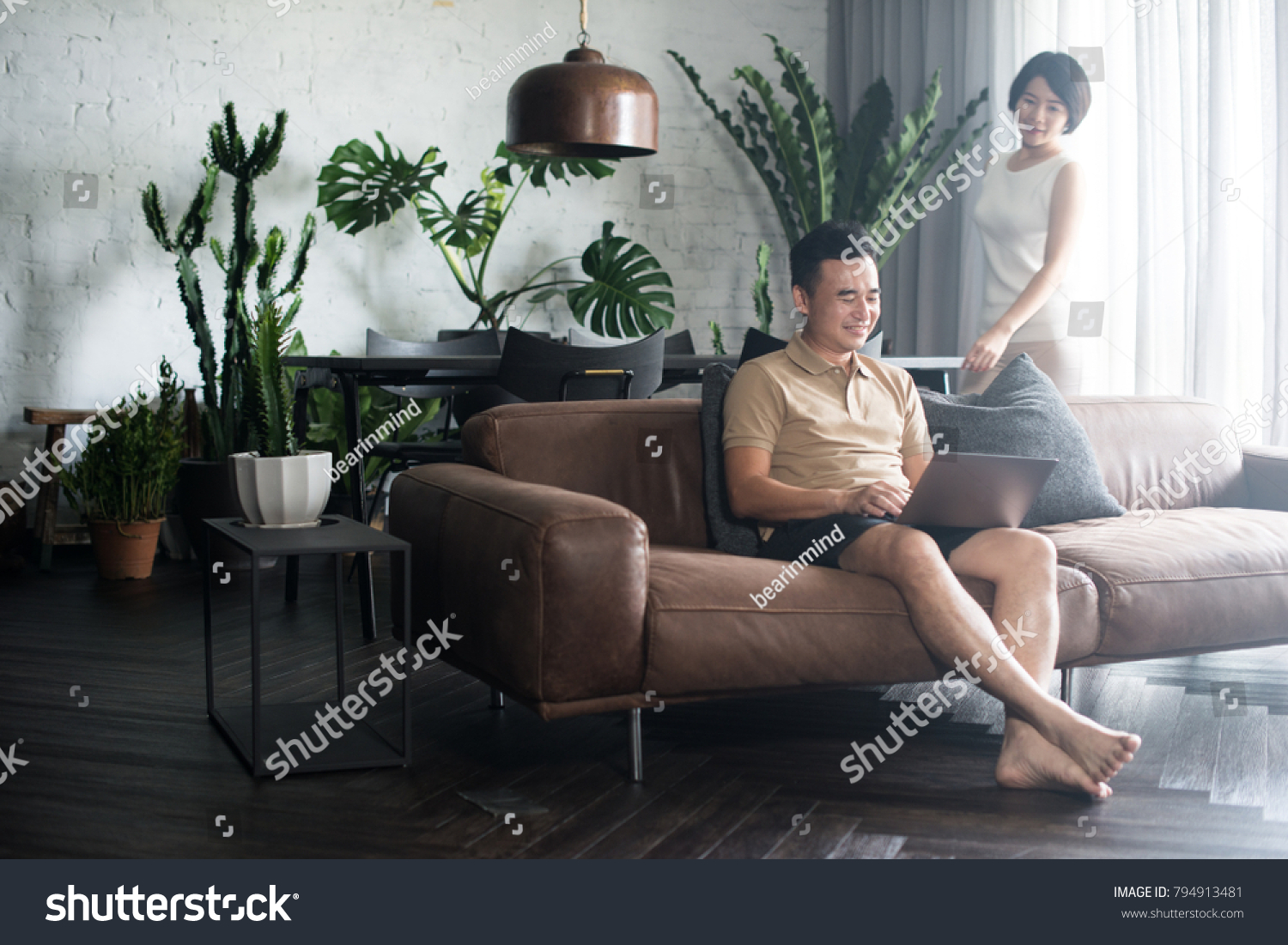 Happy Asian couple looking at the computer together at home. #794913481