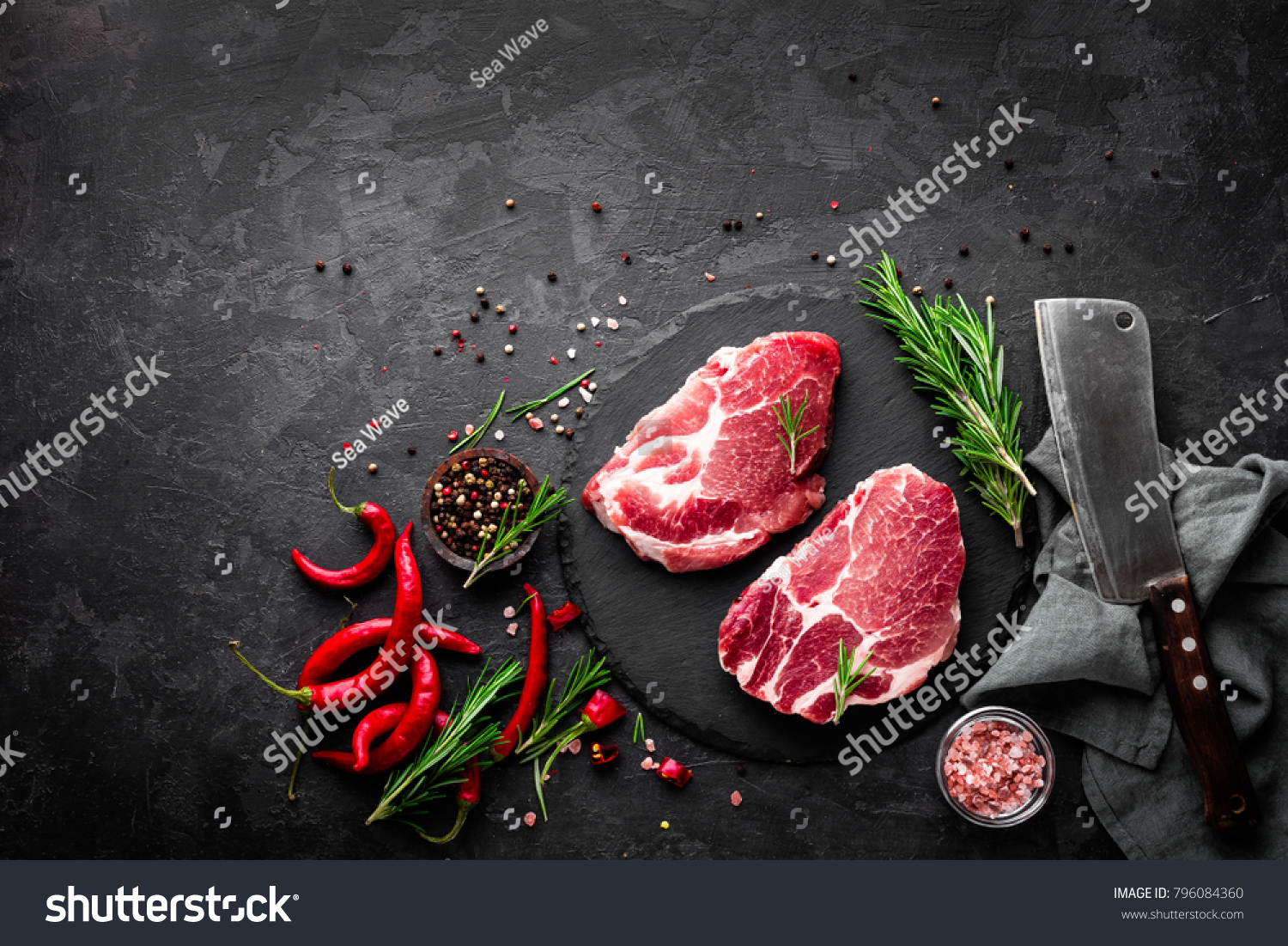 Raw pork meat. Fresh steaks on slate board on black background. Top view #796084360
