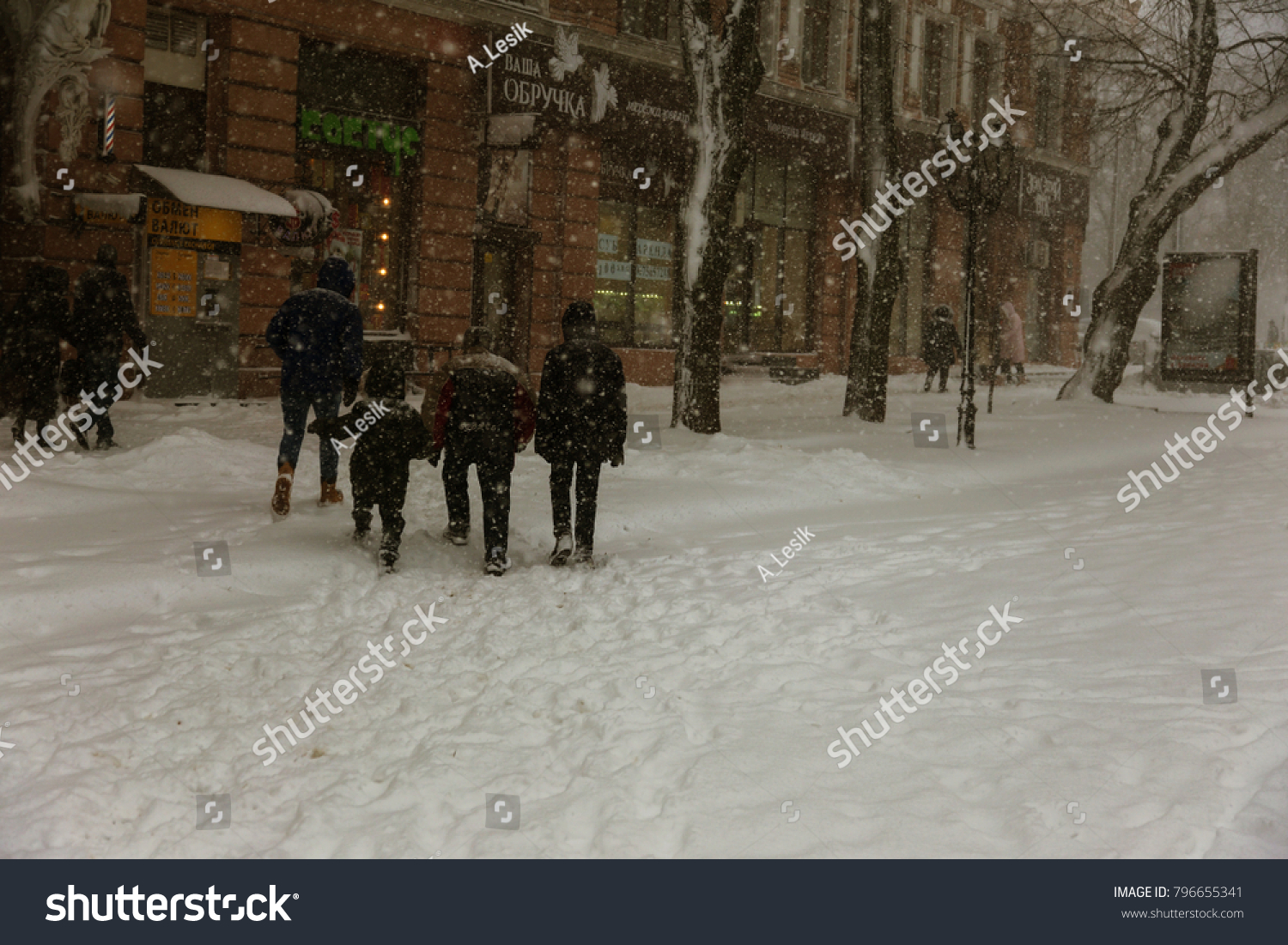 ODESSA, UKRAINE-January 16, 2018: Strong snowfall, cyclone in city streets in winter. Cars are covered with snow. Slippery road. Bad weather in winter: heavy snow and snowstorm. Pedestrians go on snow #796655341