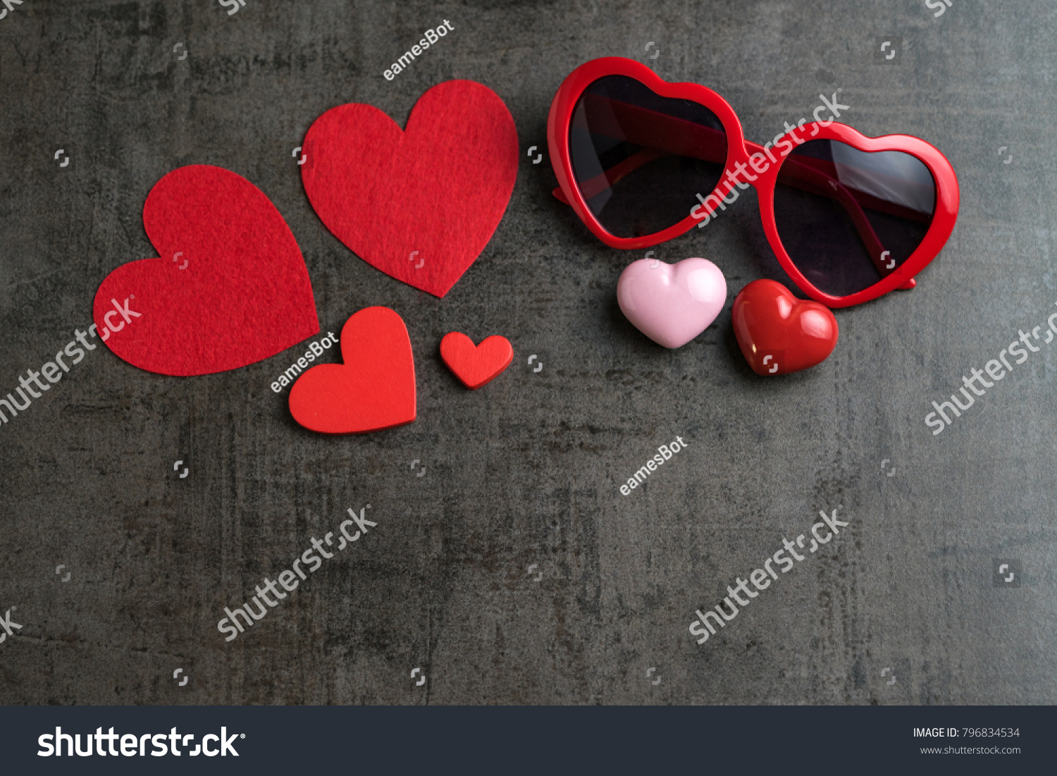 Red and pink heart shapes with heart shape eyeglasses on black cement wallpaper as Valentine's day concept with copy space. #796834534