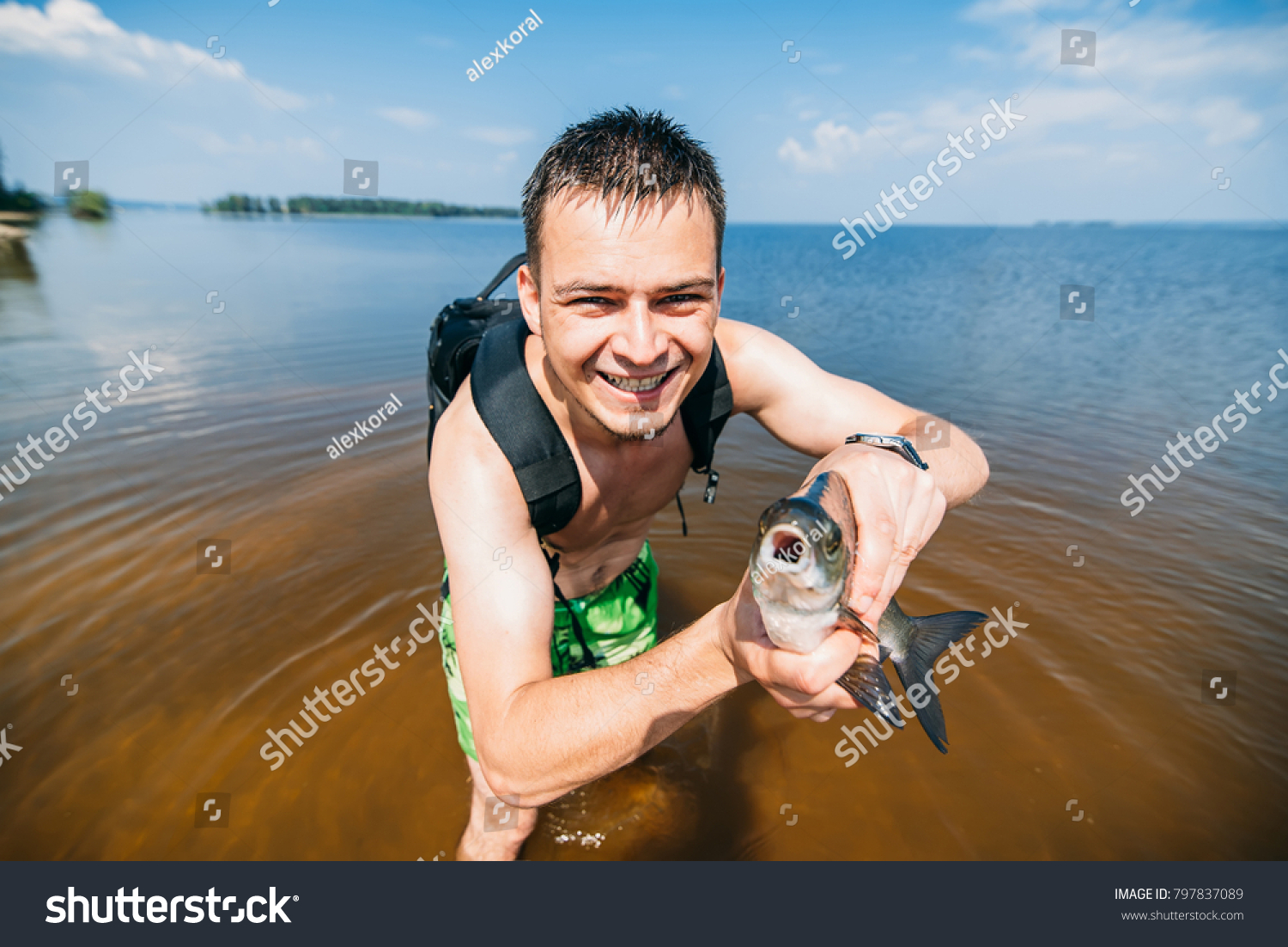 man fisherman with a large fish thrashing at the hands of a happy #797837089