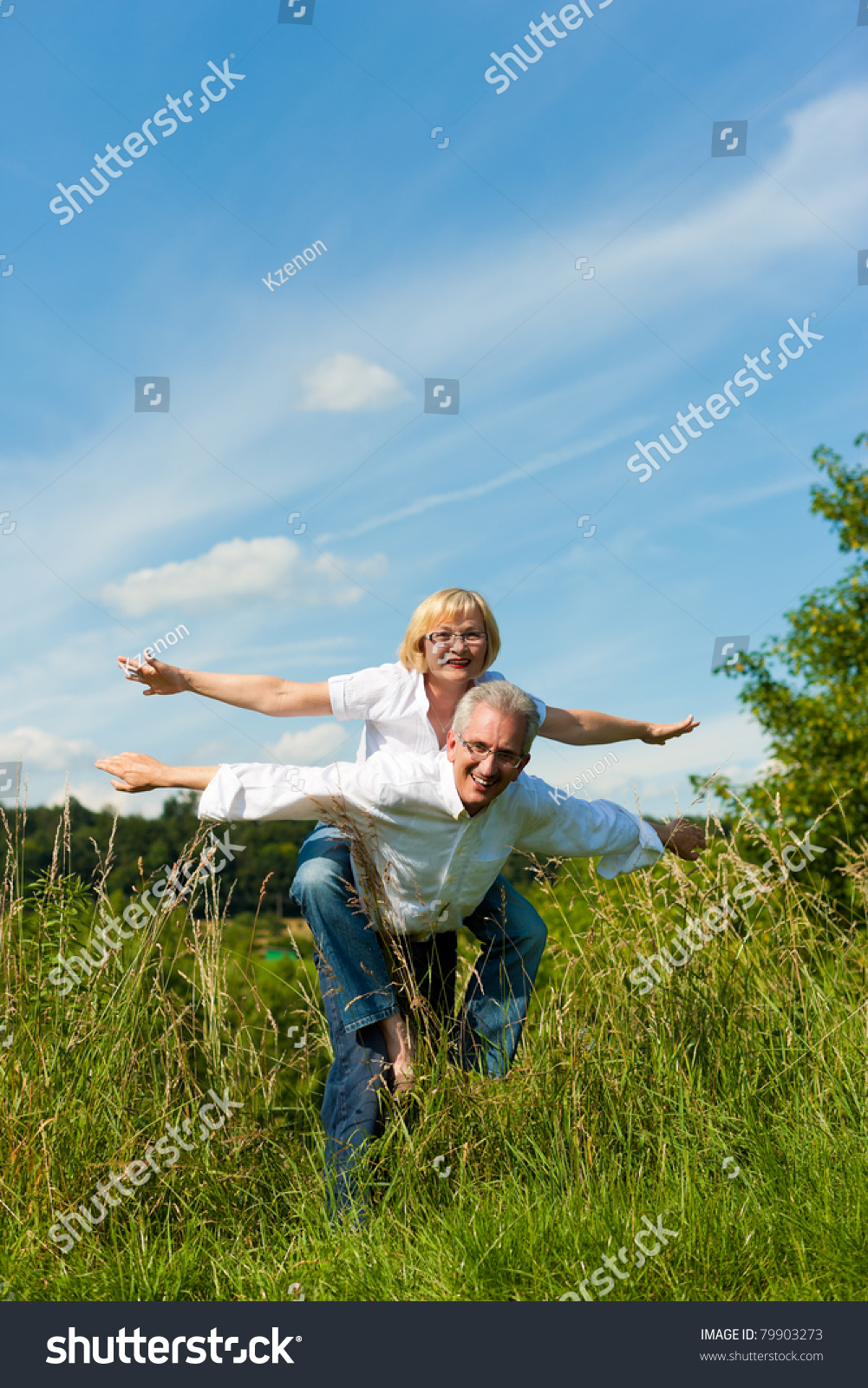 Happy mature couple - senior people (man and woman) already retired - having fun in summer in nature #79903273