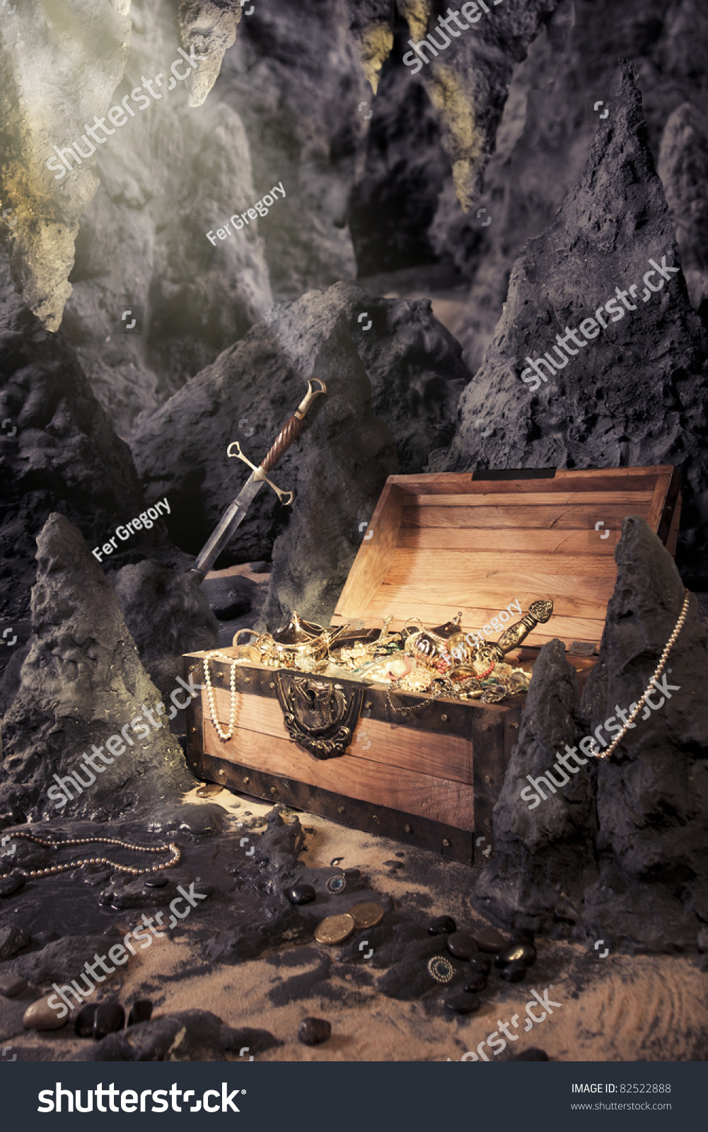 photo of open treasure chest with shinny gold in a cave #82522888