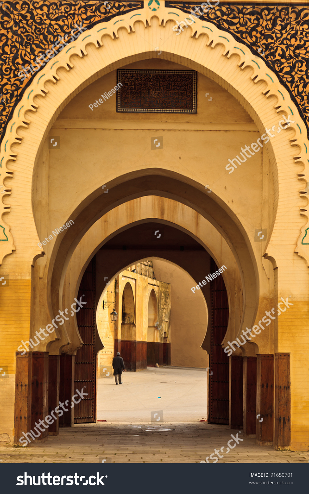 Series of intricate, ornate Moorish style curving arches of passageway into mosque courtyard in Fez, Morocco #91650701