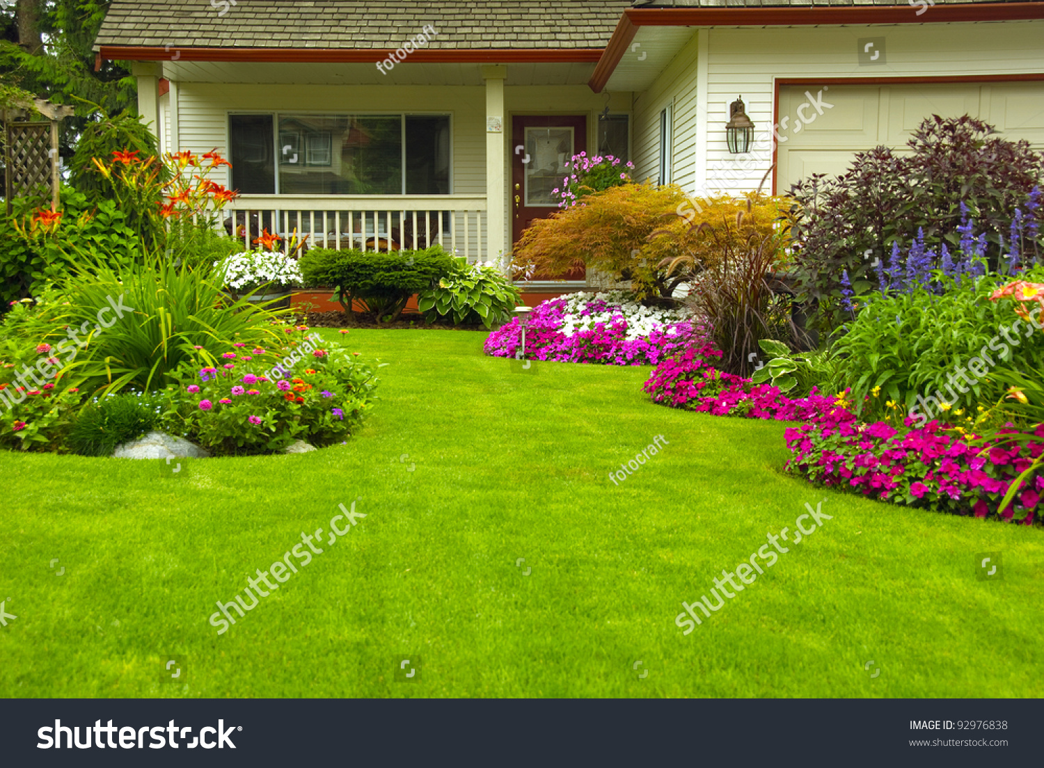 Manicured House and Garden displaying annual and perennial gardens in full bloom. #92976838