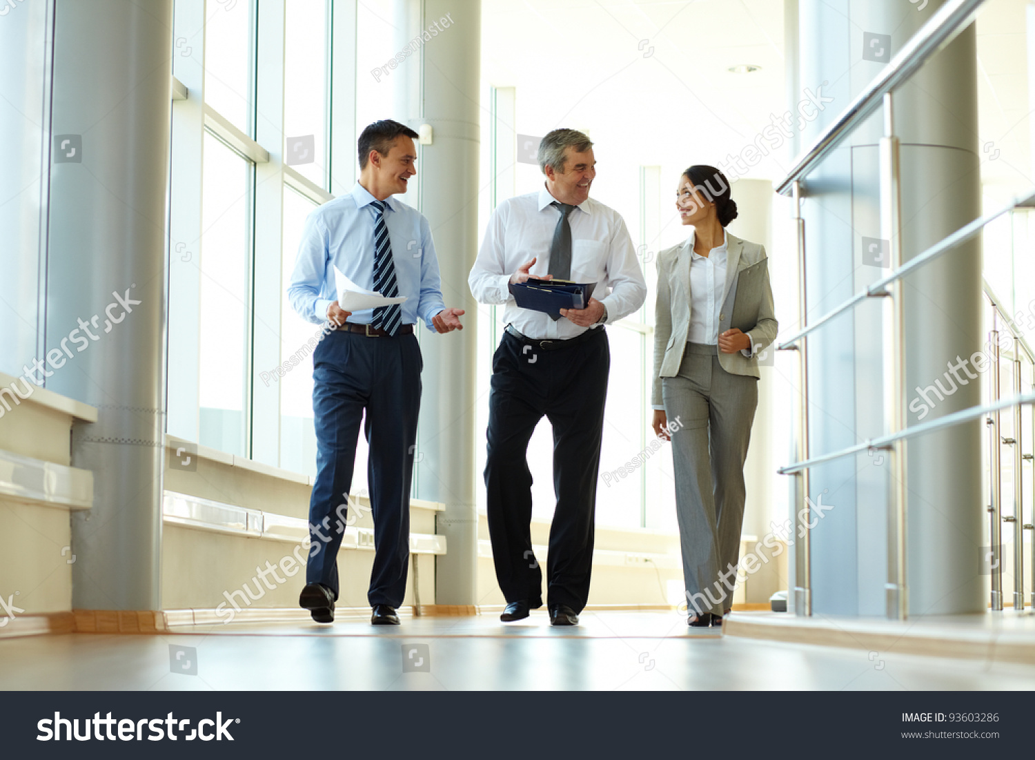 Confident business partners walking down in office building and discussing work #93603286
