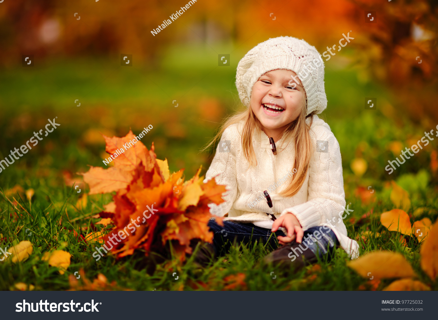 adorable little girl with autumn leaves in the beauty park #97725032