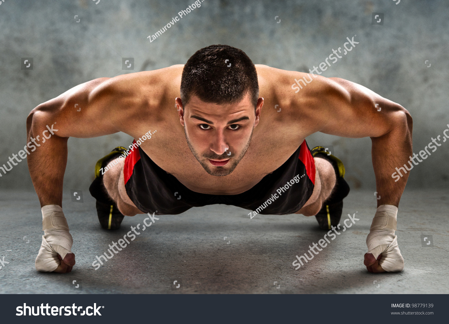 Young athletic fighter doing push ups in grunge environment./Push-up #98779139