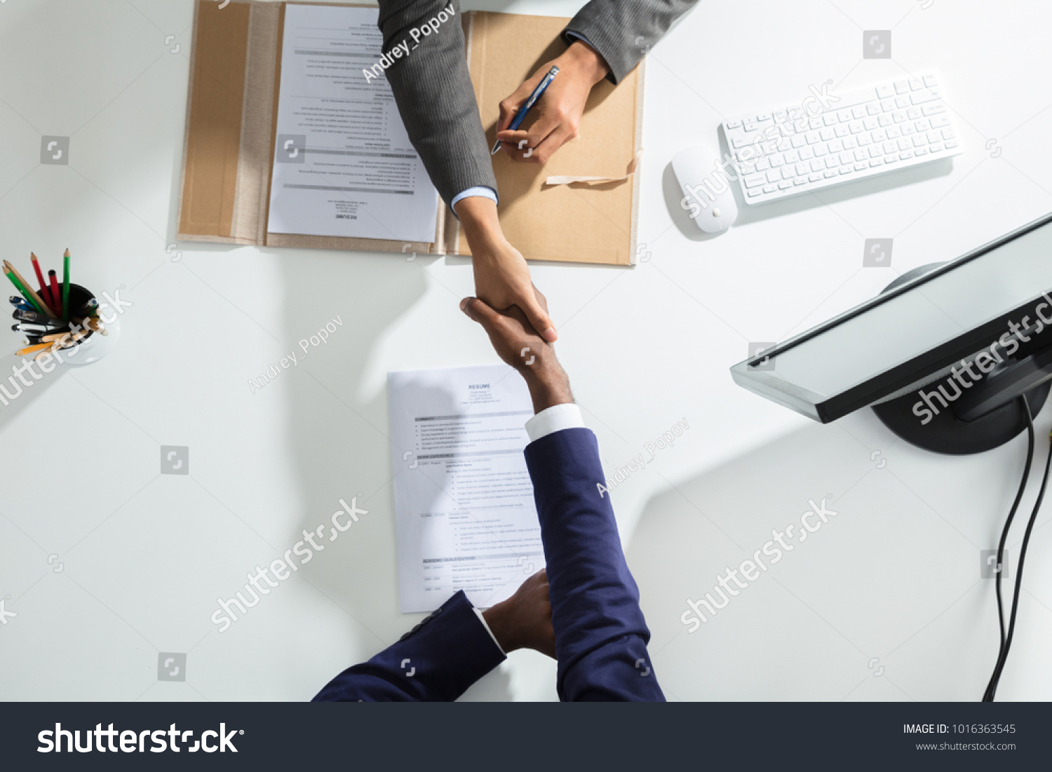 High Angle View Of Businessperson Shaking Hand With Candidate Over White Desk #1016363545