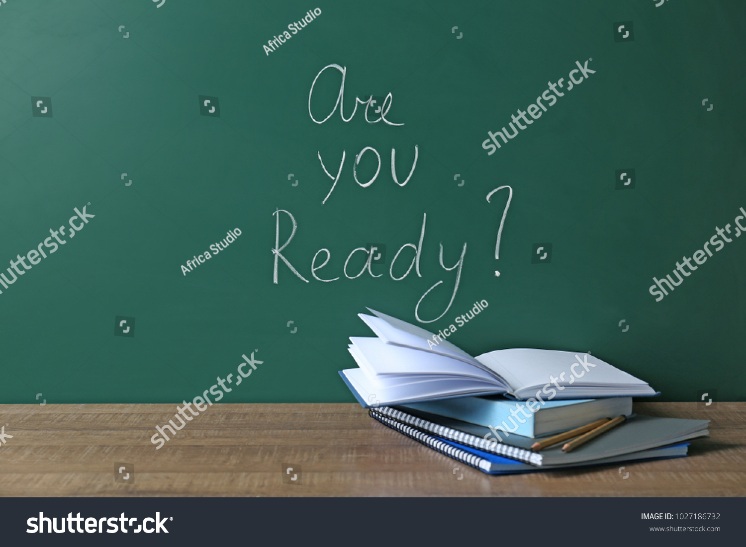 Chalkboard with question "Are you ready?" and notebooks on table. Preparing for exam #1027186732