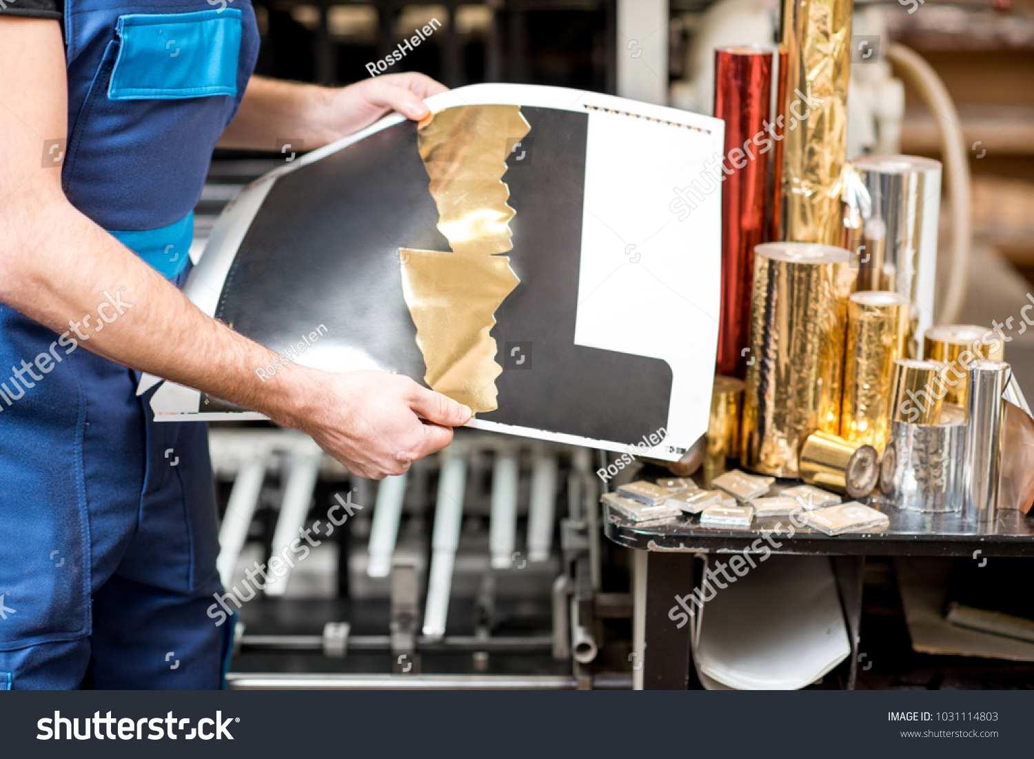 Worker checking the quality of the foil stamping at the manufacturing #1031114803