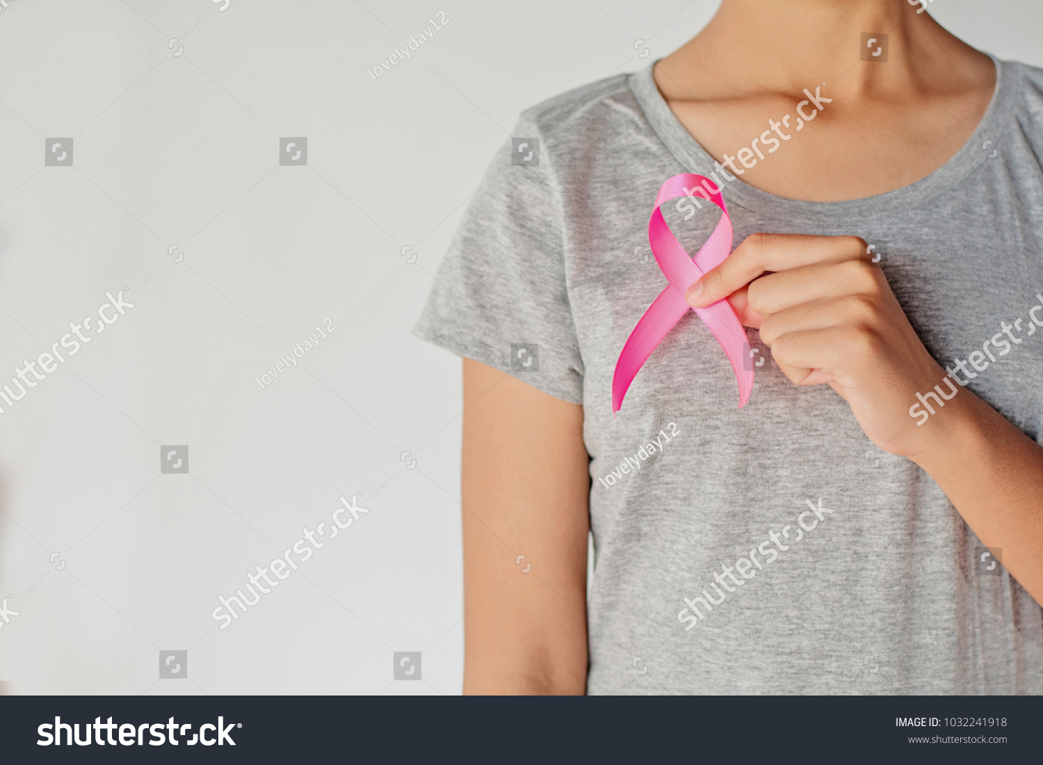 womaen hand holding pink ribbon breast cancer awareness. concept healthcare and medicine #1032241918