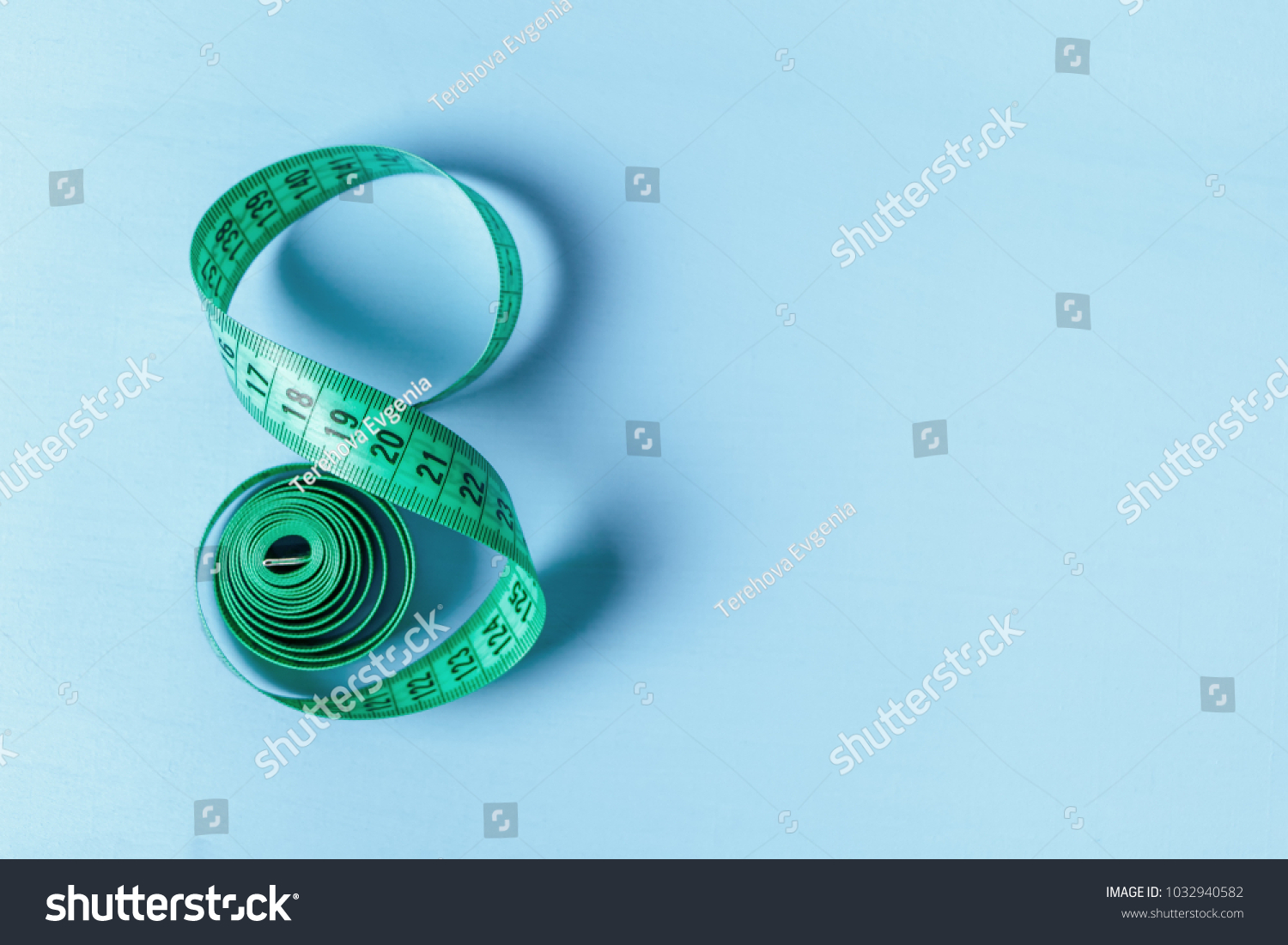 Measuring tape in the form of eight on a blue background #1032940582