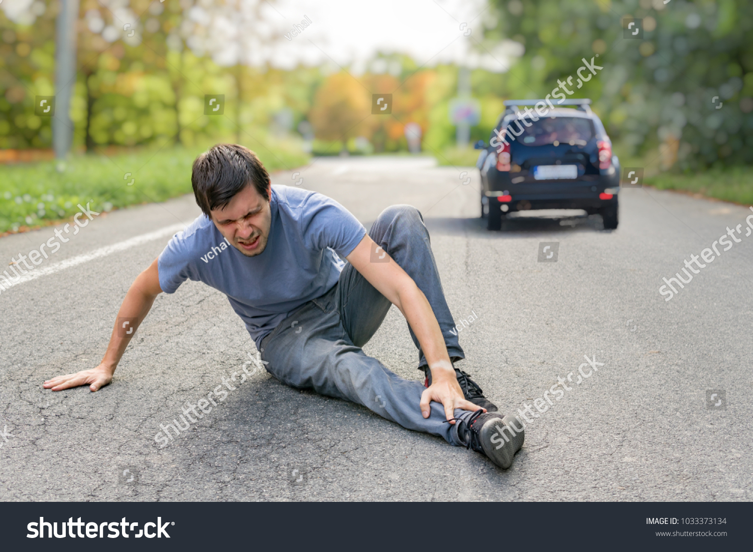 Hit and run concept. Injured man on road in front of a car. #1033373134