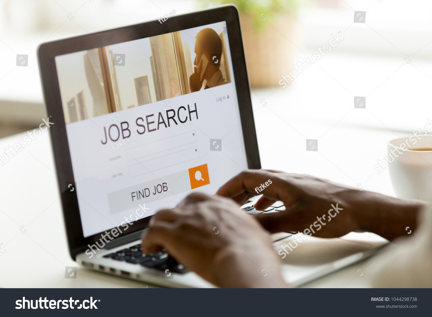 African man browsing work opportunities online using job search computer app, black jobless seeker looking for new vacancies on website page at laptop screen, recruitment concept, rear close up view #1044298738