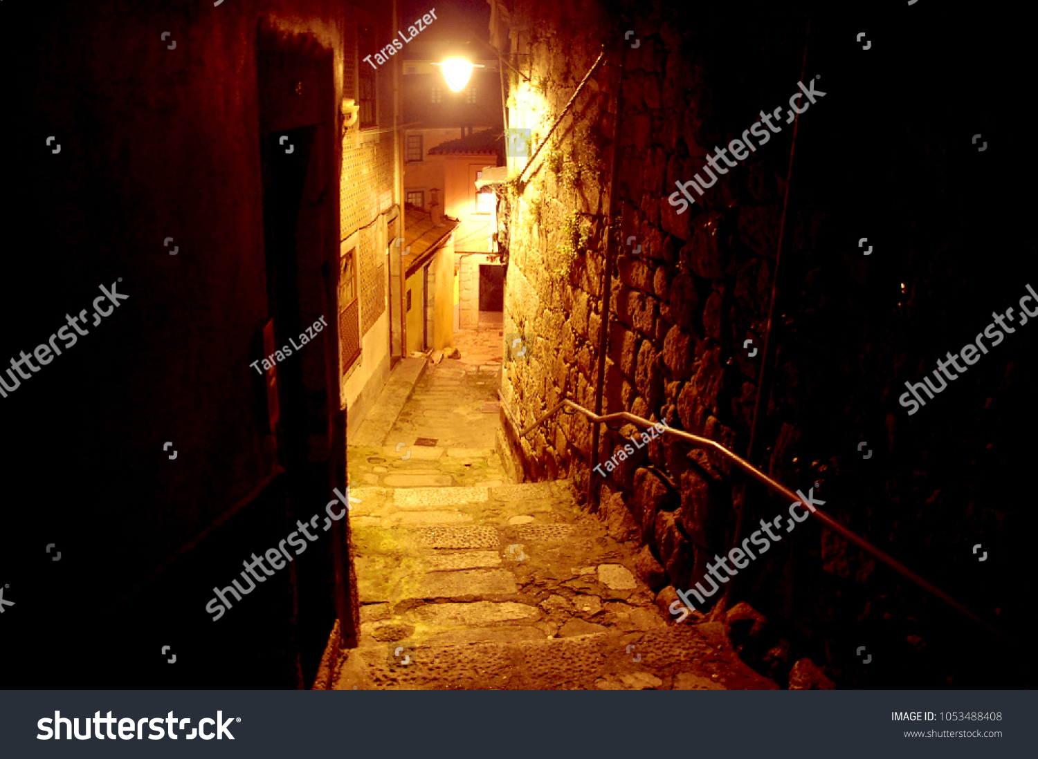 A lonely narrow street in the Porto historical old center at night #1053488408